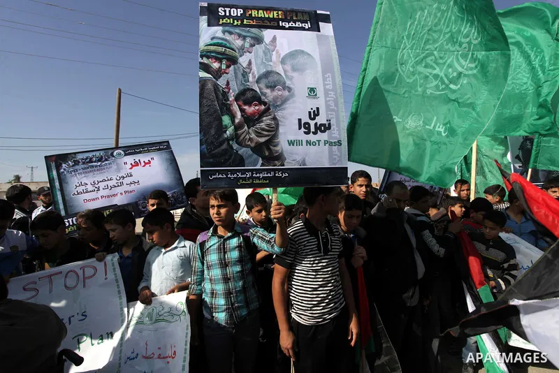 Palestinian protesters hold placards and flags during a protest against the Israeli "Prawer plan" in Gaza City on Dec. 02, 2013. "Prawer plan" is a comprehensive plan approved by Israeli government, one of whose aims is...