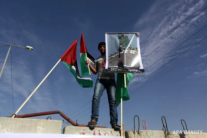 Palestinian protesters hold placards and flags during a protest against the Israeli "Prawer plan" in Gaza City on Dec. 02, 2013. "Prawer plan" is a comprehensive plan approved by Israeli government, one of whose aims is...