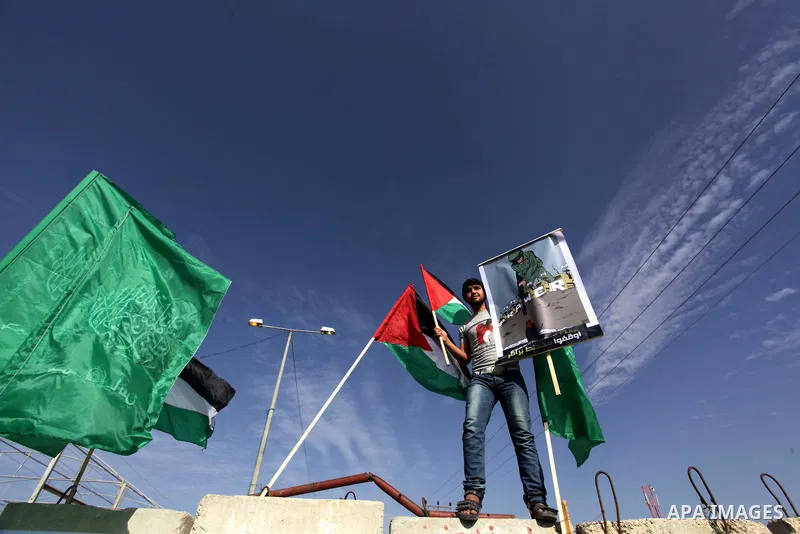 Palestinian protesters hold placards and flags during a protest against the Israeli "Prawer plan" in Gaza City on Dec. 02, 2013. "Prawer plan" is a comprehensive plan approved by Israeli government, one of whose aims is...
