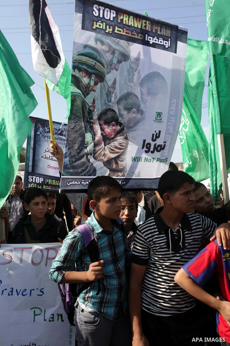 Palestinian protesters hold placards and flags during a protest against the Israeli "Prawer plan" in Gaza City on Dec. 02, 2013. "Prawer plan" is a comprehensive plan approved by Israeli government, one of whose aims is...