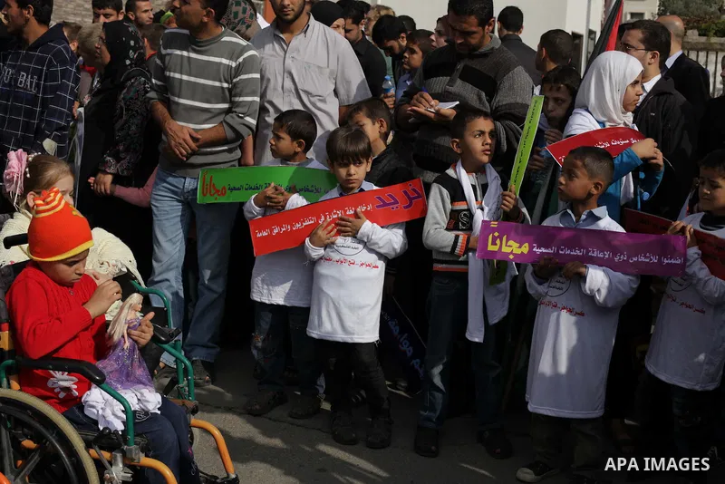 Palestinians and physically challenged people take part in a rally marking the International Day of Persons with Disabilities in Gaza City on Dec. 04, 2013. According to a United Nations report on disabilities, physical,...