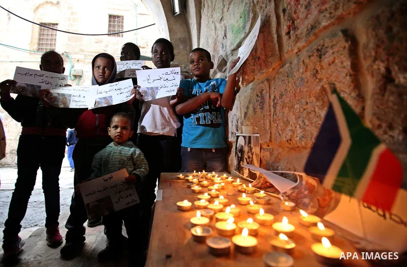 Palestinians gather at a candle memorial for late South African President Nelson Mandela in an area of Jerusalem's Old City popular to Africans, 07 December 2013. Nobel Peace Prize winner Nelson Mandela died at age 95, i...
