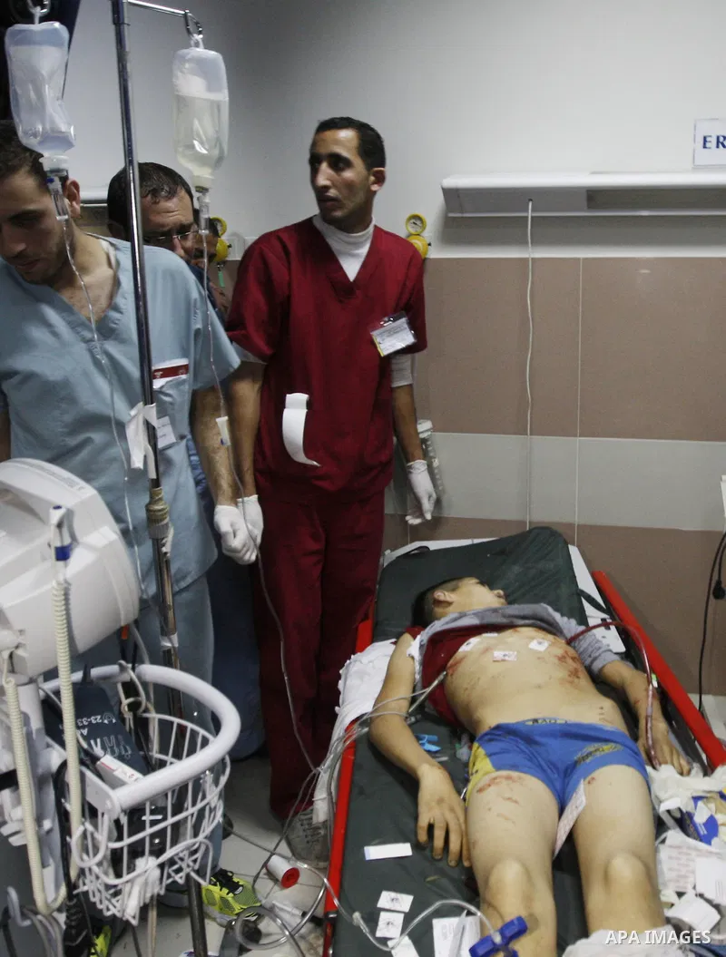 Relatives looks at the body of 15-year-old Palestinian Waji al-Ramhi as he lies in the morgue of a hospital in the West Bank city of Ramallah on December 6, 2013. Israeli troops shot dead Ramhi during early evening clash...