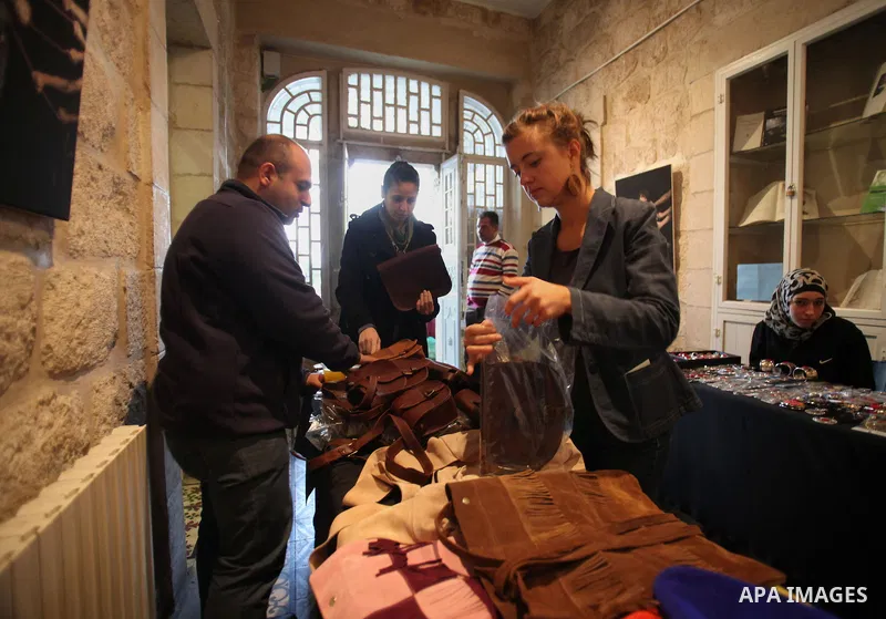 Palestinians take part in an exhibition of national products at the French chouse house, in Jerusalem on Dec. 07, 2013. Photo by Saeed Qaq