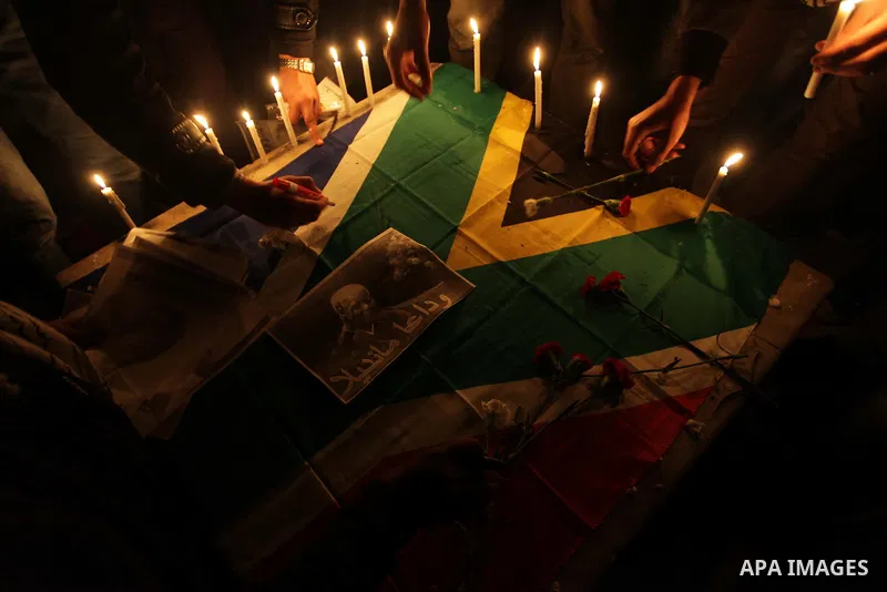 Palestinians put candles on a giant South African flag in the memory of late South African leader Nelson Mandela, during a candle vigil in Gaza City on December 8, 2013. Mandela, the revered icon of the anti-apartheid st...