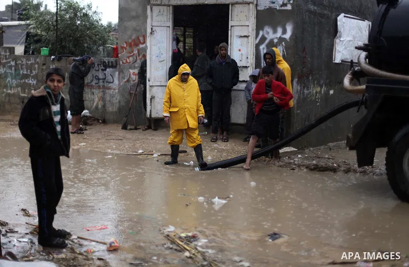 Palestinian civil defence try to drain out flooded water from a street during heavy rains on a stormy day in Gaza City, December 11, 2013. The Gaza Strip Power Authority is worried that electricity will be available for...