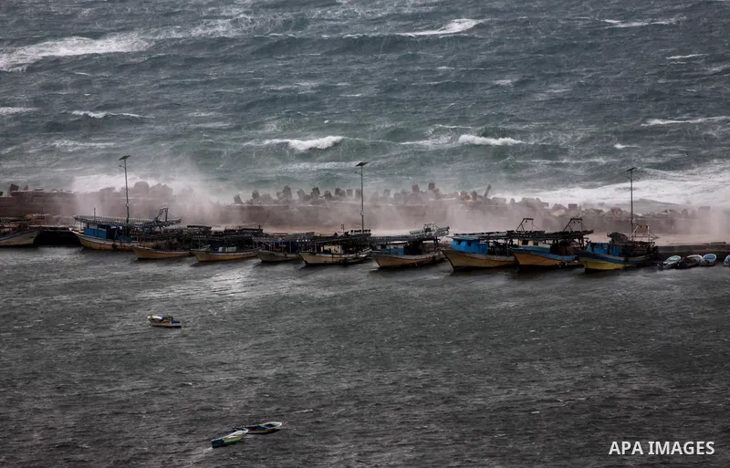 Fishing boats are seen anchored at the seaport during heavy rains on a stormy day in Gaza City, December 11, 2013. The Gaza Strip Power Authority is worried that electricity will be available for less than six hours a da...