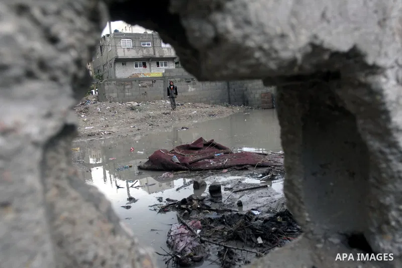 A Palestinian youth looks on a rains swamp following a downpour on a stormy day in north Gaza Strip, December 11, 2013. The Gaza Strip Power Authority is worried that electricity will be available for less than six hours...