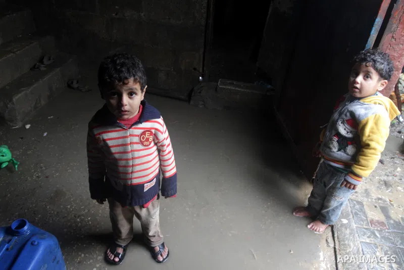 Palestinian children play at their family's house that is flooded with rainwater, on a stormy day in northen Gaza Strip, December 12, 2013. Streets in Gaza are flooded after only three hours of heavy rain which causes se...