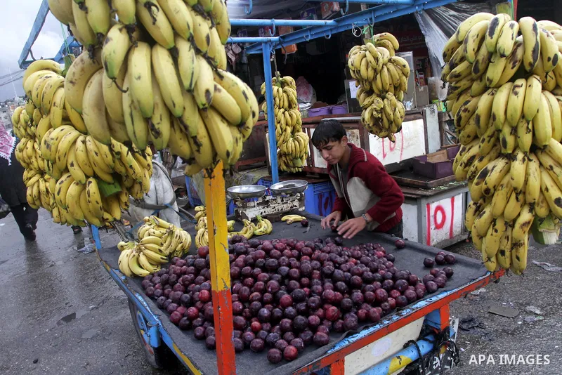 Palestinians shop at a street market during heavy rains on a stormy day in northen Gaza Strip, December 12, 2013. Streets in Gaza are flooded after only three hours of heavy rain which causes severe infrastructural damag...