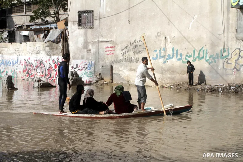 Members of the Palestinian civil defense evacuate people on a boat after their houses were flooded with rain water on a stormy day in Gaza City December 13, 2013. A severe winter deluge enveloping much of the Eastern Med...