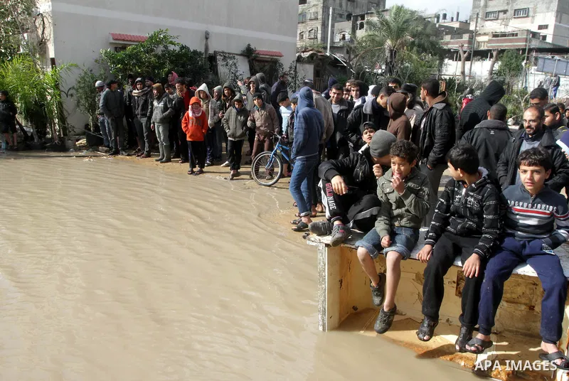 Members of the Palestinian civil defense evacuate people on a boat after their houses were flooded with rain water on a stormy day in Gaza City December 13, 2013. A severe winter deluge enveloping much of the Eastern Med...