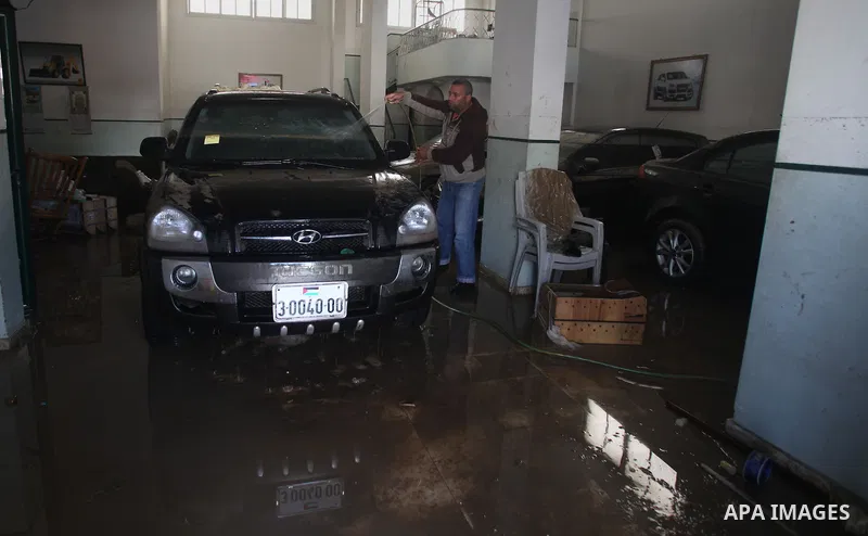 A Palestinian man cleans his cars at car showroom in Gaza City, Dec. 21, 2013. Rescue workers evacuated thousands of Gaza Strip residents from homes flooded by heavy rain, using fishing boats and heavy construction equip...