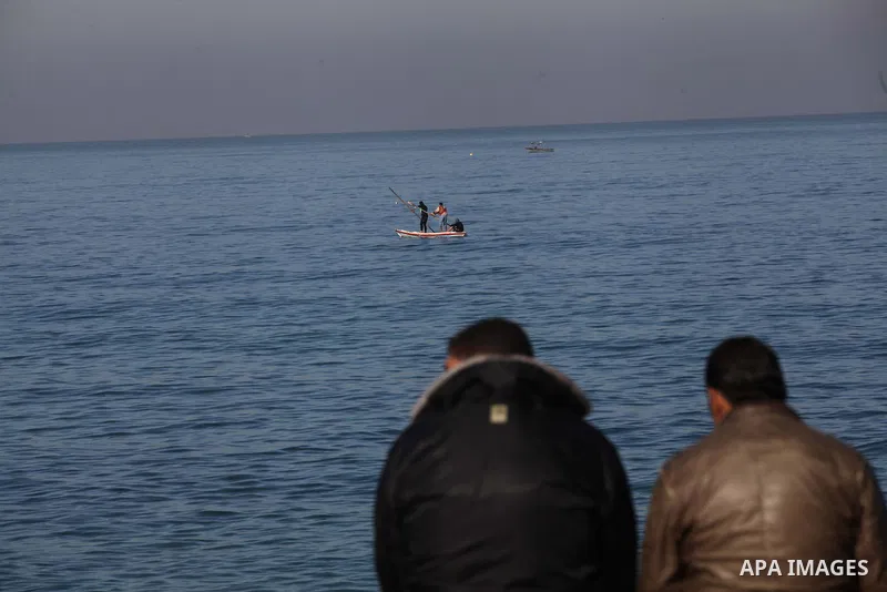 Palestinian men sit on the coastline of the Mediterranean Sea in Gaza city, on Dec. 23, 2013. Photo by Ashraf Amra