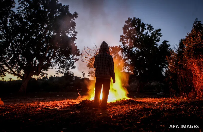 A Palestinian boy warm himself up by a firewood in Beit Lahia, northern Gaza Strip, 23 December 2013. Photo by Ezz Zanoun