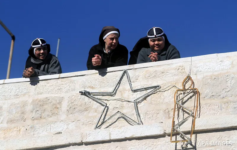 Palestinians take part in the Christmas celebrations outside the Church of the Nativity in the West Bank city of Bethlehem on Dec. 24, 2013. Thousands of Christian pilgrims gathered in Bethlehem's Manger Square to celebr...