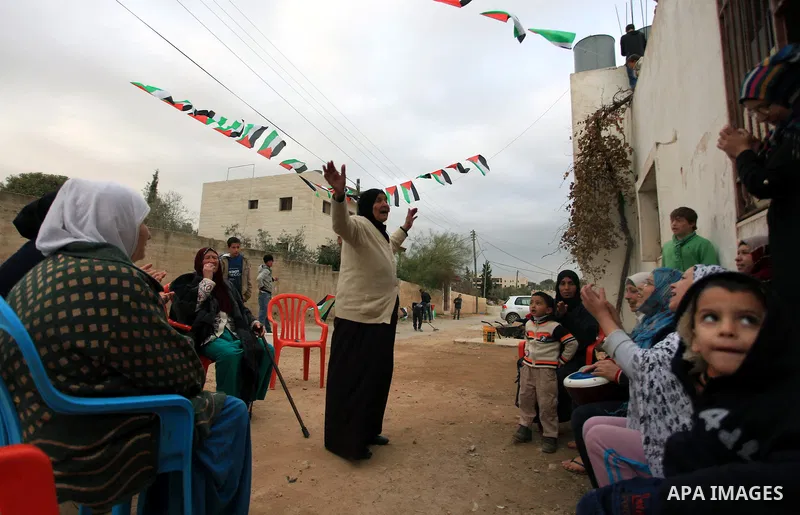 Palestinian relatives of prisoner Saeed Tamimi celebrate outside his home at Nabi Saleh village near the West Bank city of Ramallah, Sunday, Dec. 29, 2013. The Israeli prison service published Saturday night on its websi...