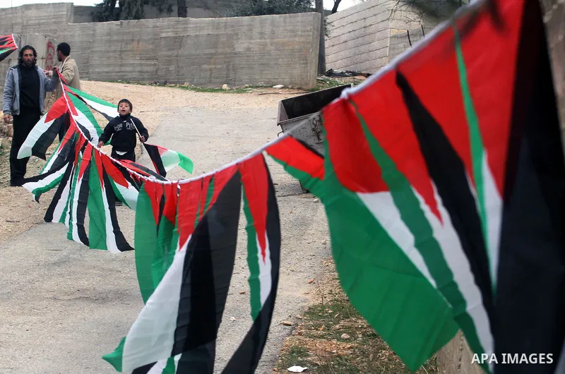 Palestinian relatives of prisoner Saeed Tamimi hang flags outside his home at Nabi Saleh village near the West Bank city of Ramallah, Sunday, Dec. 29, 2013. The Israeli prison service published Saturday night on its webs...
