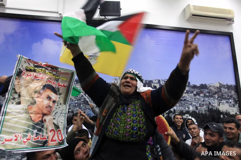 Friends and family members of the 26 Palestinian prisoners who are expected to be released on December 30, 2013 celebrate their imminent release from Israeli jail in the West Bank city of Ramallah. The 26 prisoners expec...