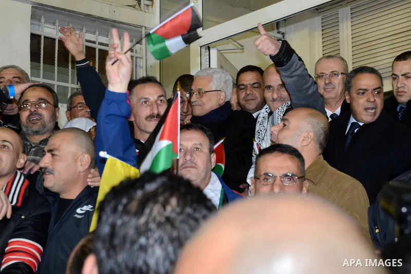 Palestinian President Mahmoud Abbas greets released prisoners upon their arrival outside Abbas's headquarters in the West Bank city of Ramallah on December 31, 2013. Israel freed 26 Palestinian prisoners who were jailed...