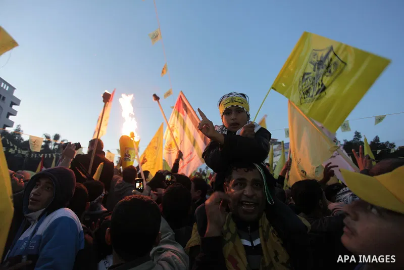 Palestinian supporters of Fatah movement hold the party's torch during a rally in Gaza city on December 31, 2013. Tens of thousands of Fatah supporters rallied in Gaza City on Tuesday to celebrate the 49th anniversary of...