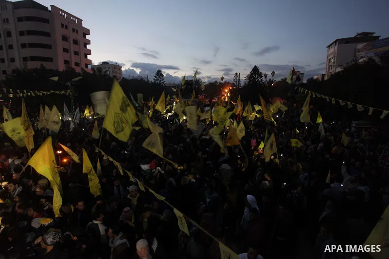 Palestinian supporters of Fatah movement hold the party's torch during a rally in Gaza city on December 31, 2013. Tens of thousands of Fatah supporters rallied in Gaza City on Tuesday to celebrate the 49th anniversary of...