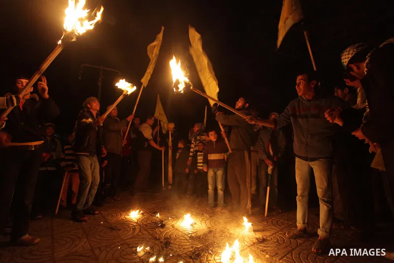 Palestinian supporters of Fatah movement hold the party's torch during a rally in Gaza city on December 31, 2013. Tens of thousands of Fatah supporters rallied in Gaza City on Tuesday to celebrate the 49th anniversary of...