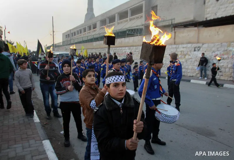 Palestinian boys hold torch during a march to mark he 49th anniversary of the formation of the Fatah movement in the West Bank village of Burqa near Nablus City, 01 January 2014. Photo by Nedal Eshtayah