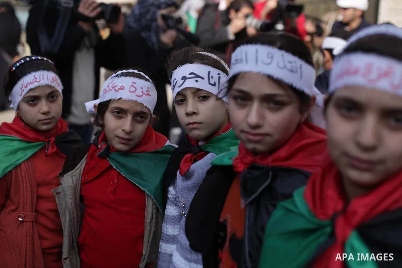 Palestinian Children hold banners during a protest in solidarity with Palestinian children at Yarmouk refugee camp, in front of the Palestinian Red Cross, in Gaza City on Jan. 04, 2013. Palestinian president Mahmoud Abba...