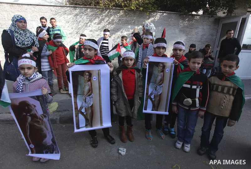 Palestinian Children hold banners during a protest in solidarity with Palestinian children at Yarmouk refugee camp, in front of the Palestinian Red Cross, in Gaza City on Jan. 04, 2013. Palestinian president Mahmoud Abba...