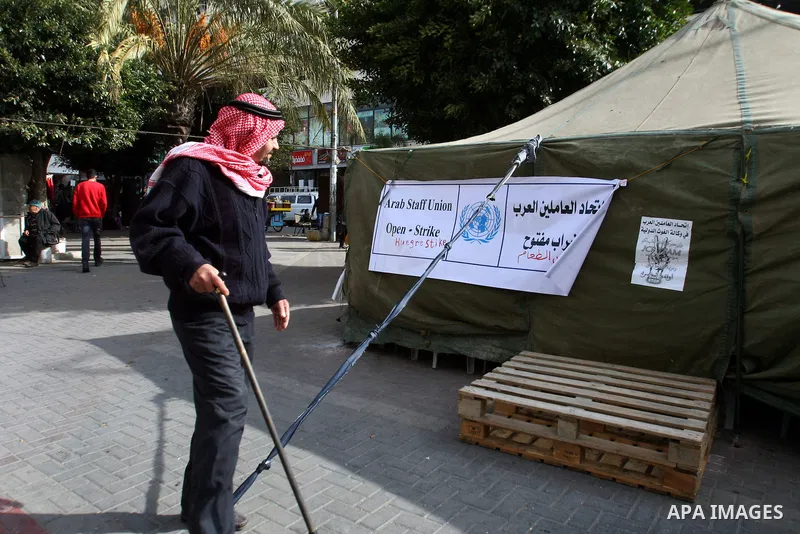 A Palestinian man walks past a protest tent for Arab staff Union to demanded the return rights of Palestinian refugees, in the West Bank city of Nablus, on Jan. 04, 2013. Photo by Nedal Eshtayah