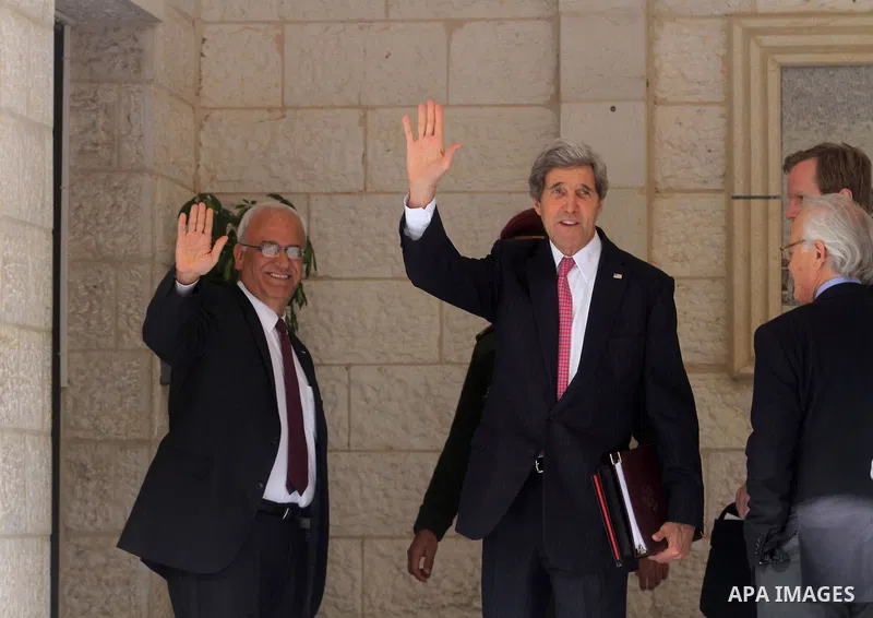 U.S. Secretary of State John Kerry, center, and chief Palestinian negotiator Saeb Erekat wave prior to a meeting with Palestinian President Mahmoud Abbas in the West Bank city of Ramallah, Saturday, Jan. 4, 2014. Kerry i...