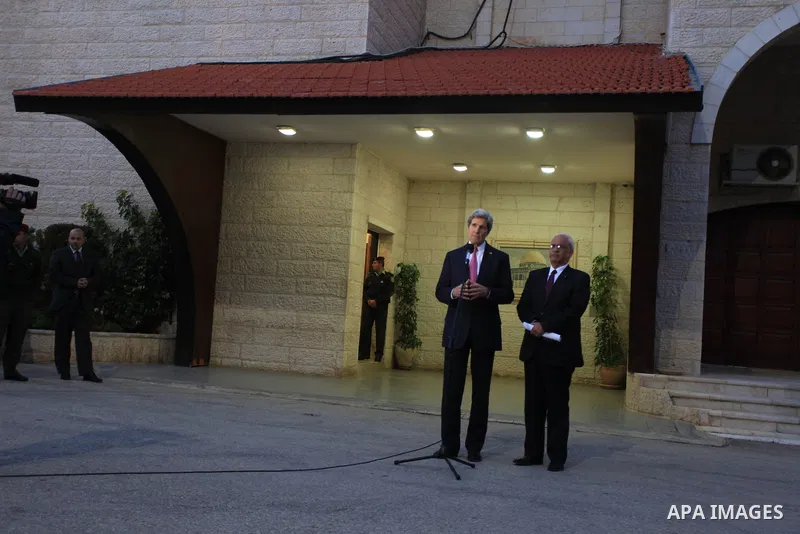 Palestinian negotiator Saeb Erekat listens as U.S. Secretary of State John Kerry (L) speaks to the media after a meeting with Palestinian President Mahmoud Abbas (not pictured) in the West Bank city of Ramallah January 4...