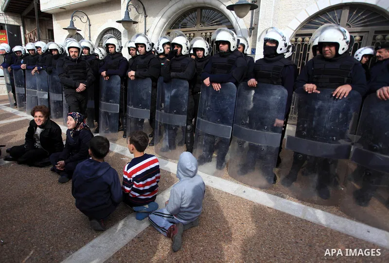 Riot police stand guard as Palestinian protesters demonstrate outside a hotel where a group of Israeli and Palestinian peace activists hold a meeting in the West Bank city of Ramallah, Thursday, Jan. 9, 2014. Protesters...