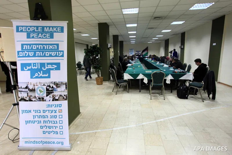 Palestinian and Israeli peace activists take part in a meeting at a hotel in the West Bank city of Ramallah, Thursday, Jan. 9, 2014. Dozens of Palestinian protesters gathered outside the hotel during a demonstration to p...