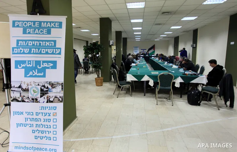 Palestinian and Israeli peace activists take part in a meeting at a hotel in the West Bank city of Ramallah, Thursday, Jan. 9, 2014. Dozens of Palestinian protesters gathered outside the hotel during a demonstration to p...