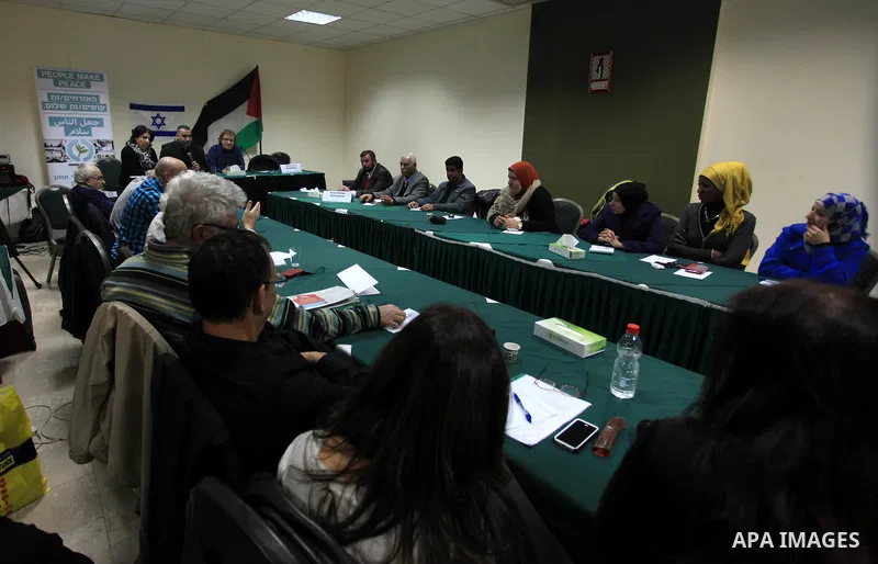 Palestinian and Israeli peace activists take part in a meeting at a hotel in the West Bank city of Ramallah, Thursday, Jan. 9, 2014. Dozens of Palestinian protesters gathered outside the hotel during a demonstration to p...