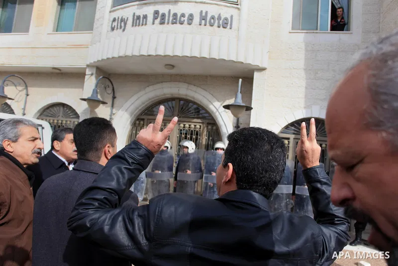 Riot police stand guard as Palestinian protesters demonstrate outside a hotel where a group of Israeli and Palestinian peace activists hold a meeting in the West Bank city of Ramallah, Thursday, Jan. 9, 2014. Protesters...
