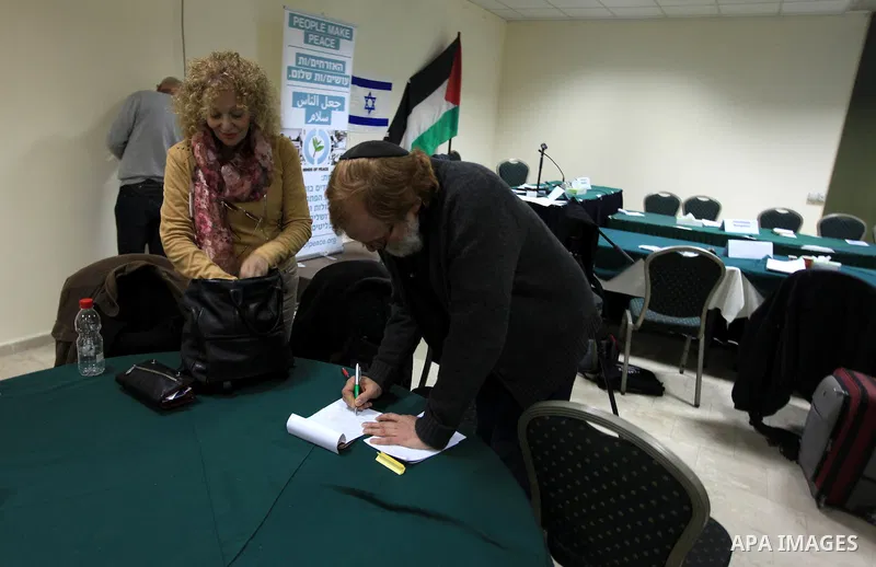 Palestinian and Israeli peace activists take part in a meeting at a hotel in the West Bank city of Ramallah, Thursday, Jan. 9, 2014. Dozens of Palestinian protesters gathered outside the hotel during a demonstration to p...
