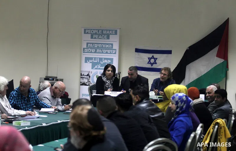 Palestinian and Israeli peace activists take part in a meeting at a hotel in the West Bank city of Ramallah, Thursday, Jan. 9, 2014. Dozens of Palestinian protesters gathered outside the hotel during a demonstration to p...