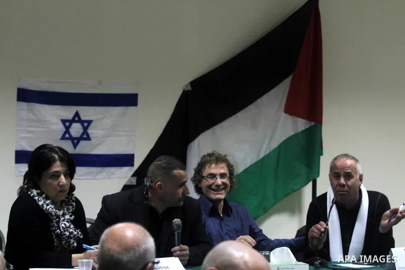 Palestinian and Israeli peace activists take part in a meeting at a hotel in the West Bank city of Ramallah, Thursday, Jan. 9, 2014. Dozens of Palestinian protesters gathered outside the hotel during a demonstration to p...