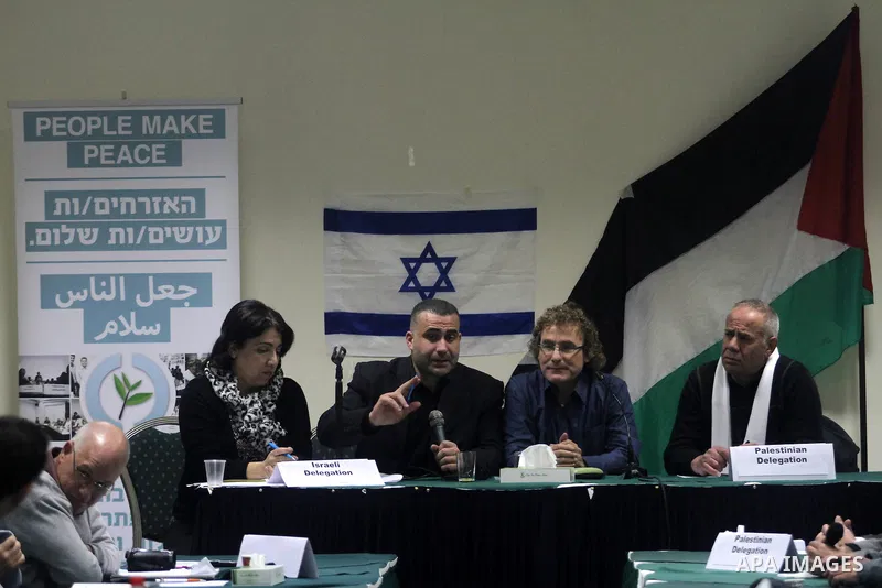 Palestinian and Israeli peace activists take part in a meeting at a hotel in the West Bank city of Ramallah, Thursday, Jan. 9, 2014. Dozens of Palestinian protesters gathered outside the hotel during a demonstration to p...