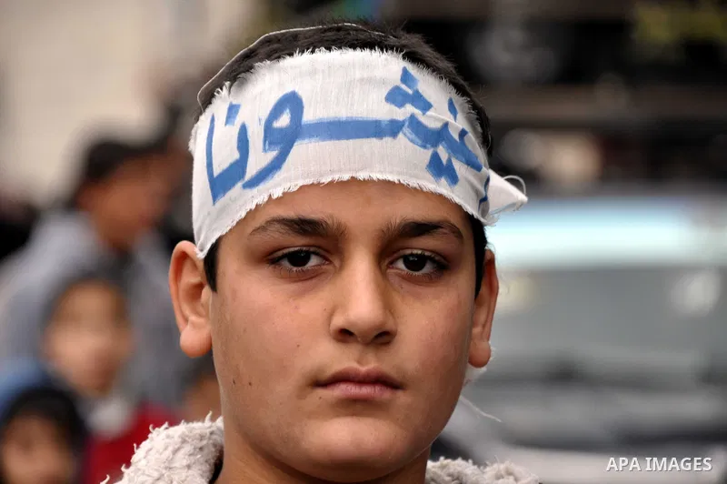 Palestinian boys take part in a rally to show solidarity with Palestinian refugees in Syria's main refugee camp Yarmouk, in Jabalia in the northern Gaza Strip January 10, 2014. Photo by Mohammed Talatene