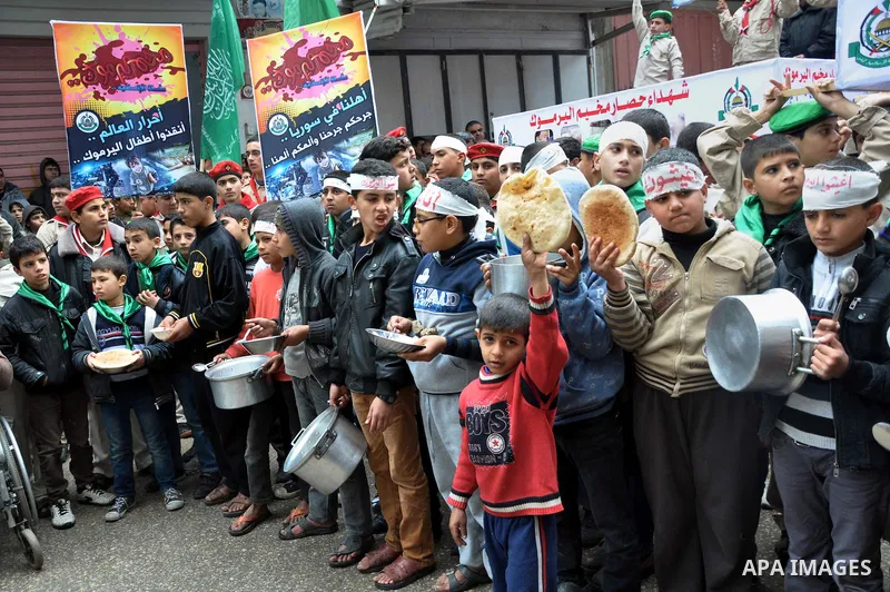 Palestinian boys take part in a rally to show solidarity with Palestinian refugees in Syria's main refugee camp Yarmouk, in Jabalia in the northern Gaza Strip January 10, 2014. Photo by Mohammed Talatene
