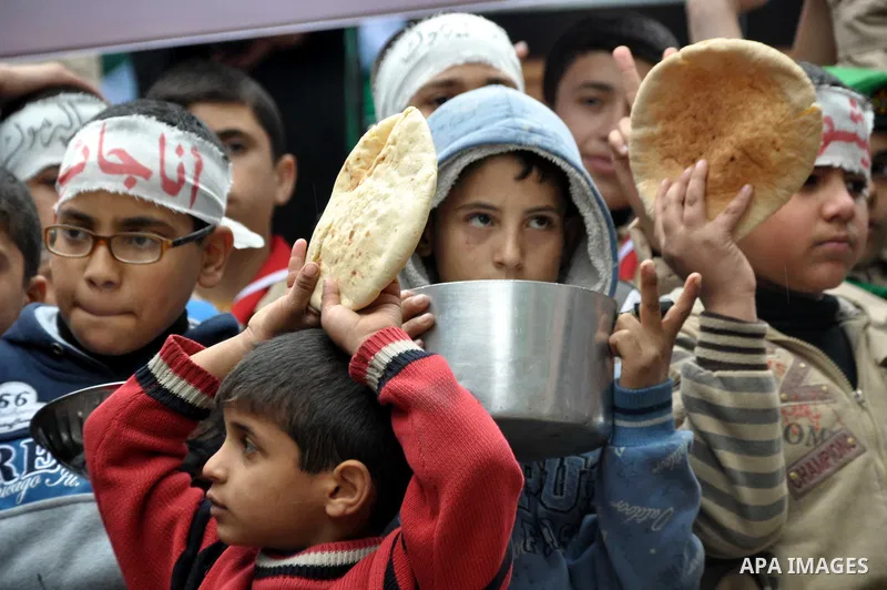 Palestinian boys take part in a rally to show solidarity with Palestinian refugees in Syria's main refugee camp Yarmouk, in Jabalia in the northern Gaza Strip January 10, 2014. Photo by Mohammed Talatene