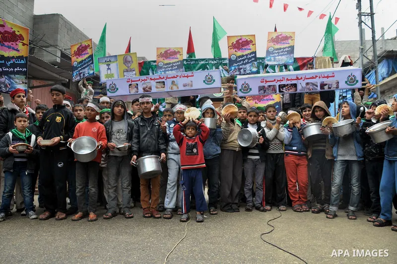 Palestinian boys take part in a rally to show solidarity with Palestinian refugees in Syria's main refugee camp Yarmouk, in Jabalia in the northern Gaza Strip January 10, 2014. Photo by Mohammed Talatene