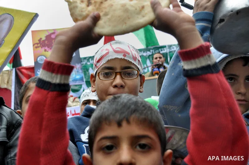 Palestinian boys take part in a rally to show solidarity with Palestinian refugees in Syria's main refugee camp Yarmouk, in Jabalia in the northern Gaza Strip January 10, 2014. Photo by Mohammed Talatene