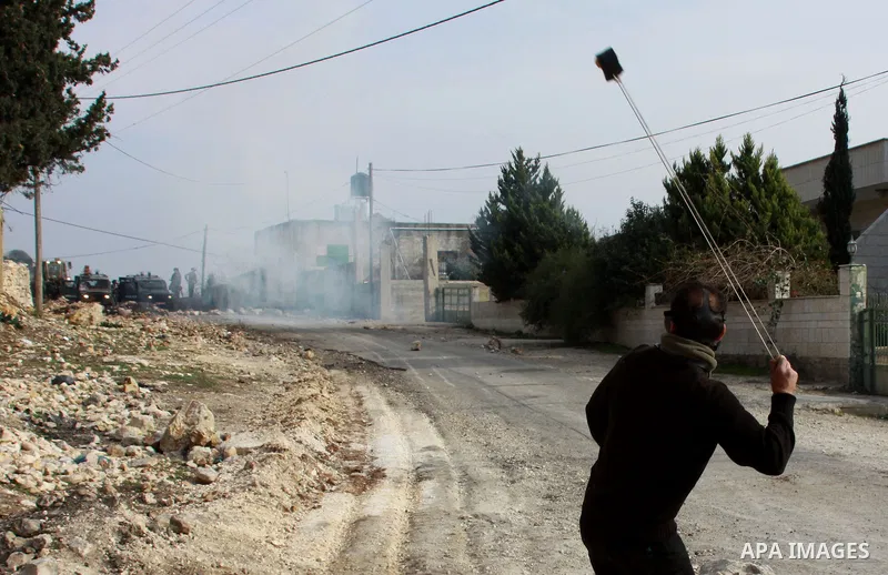 A Palestinian protester hurls a stone at Israeli security forces as clashes broke out during a demonstration against the expropriation of Palestinian land by Israel in the village of Kfar Qaddum, near the occupied West B...