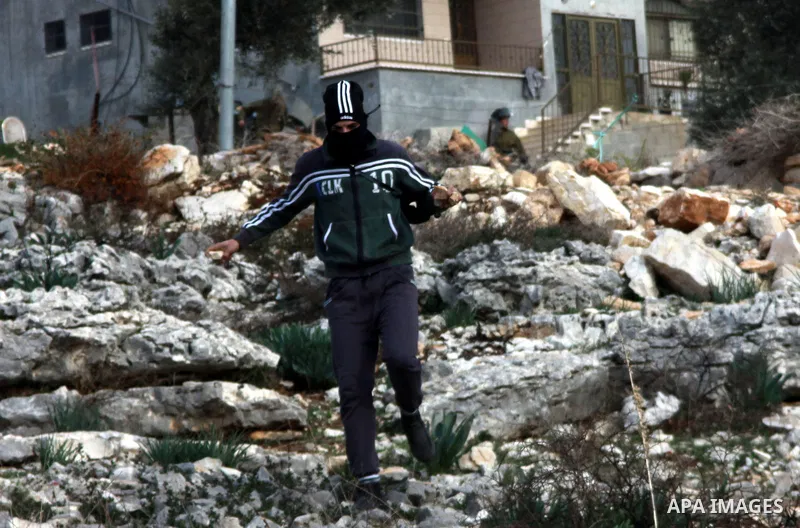 A Palestinian protester throws stones at Israeli security forces as clashes broke out during a demonstration against the expropriation of Palestinian land by Israel in the village of Kfar Qaddum, near the occupied West B...
