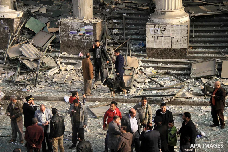 Egyptian policemen stand outside the court in the working class Imbaba neighbourhood of Cairo on January 14, 2014 after blast hit the building two hours before polls opened for Egyptians to vote on a new constitution. Th...
